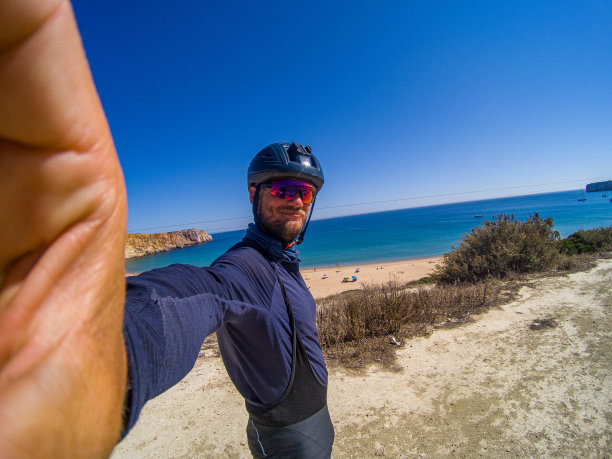 白人年轻男子骑自行车在海滩上自拍图片下载