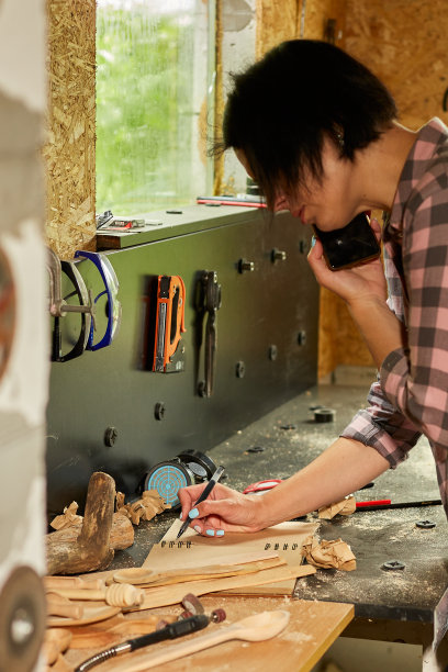 快乐的女木匠在智能手机上与她的客户讨论订单细节图片下载