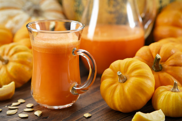 一杯南瓜汁。厨房桌上的南瓜。一壶南瓜汁作为背景。图片下载