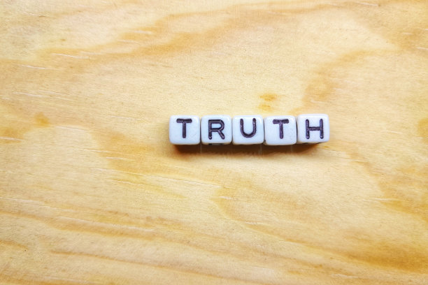 在木制背景上写着“真相”的字母块或字母骰子图片下载