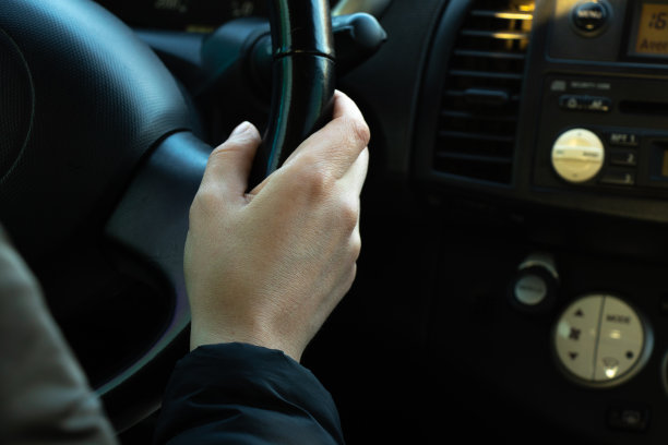 在阳光下的下午，手放在方向盘上图片下载