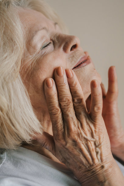 近距离肖像老年妇女使用保湿面霜，享受抗衰老的护肤程序。天然抗衰老化妆品。产品用于美容、护肤、彩妆。图片下载