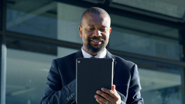 数码平板电脑，办公室和商人在城市网络上网或浏览互联网。技术、专业和企业的非洲老板用移动设备在社交媒体上滚动。图片下载