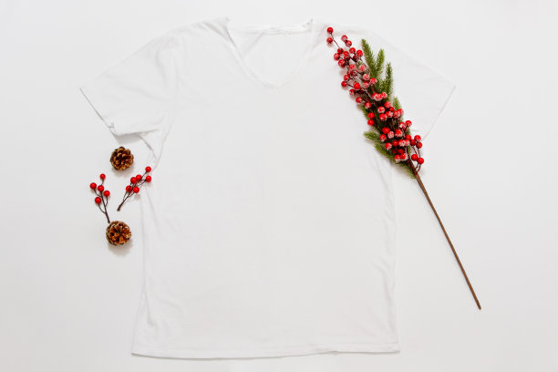 封闭白色空白模板t恤与复制空间和圣诞假期的概念。顶部视图模型t恤和红色节日装饰在白色背景。拜年饰品。圣诞衣服图片下载