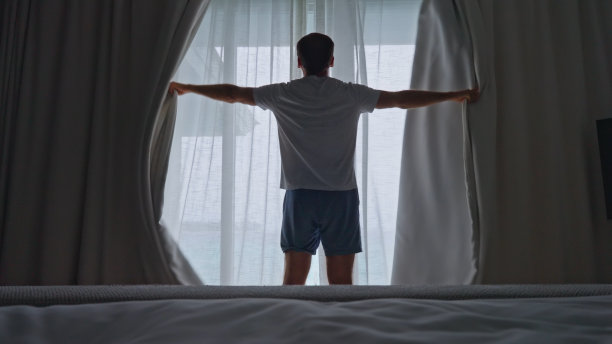 人们在早上打开窗帘以获得日光图片下载