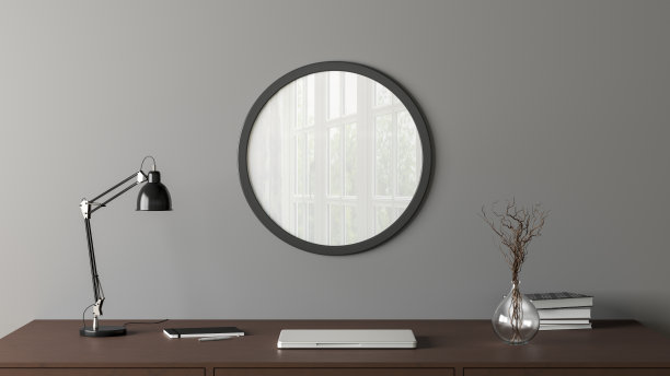 黑色木制圆形海报框架模拟在家庭工作室工作空间的灰色墙壁上。前视图。图片下载