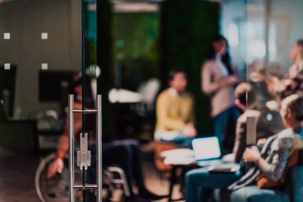 一位坐在轮椅上休息的女商人，身后是她的团队图片下载