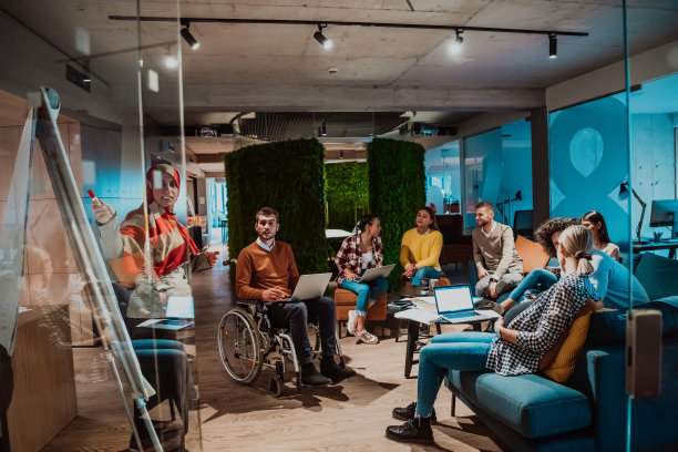 一位年长的穆斯林女商人向现代办公室里年轻的多元化团队展示一个项目图片下载