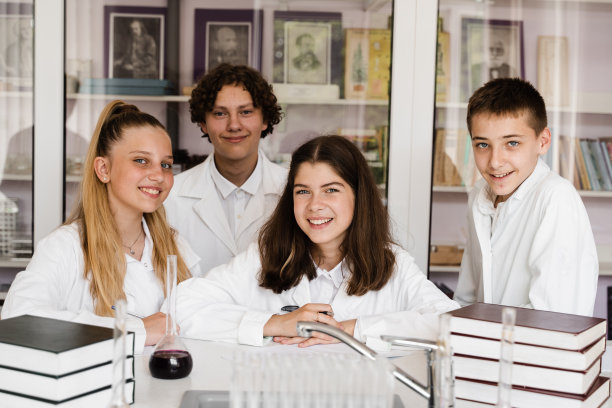 学校教育。化学课上兴高采烈的同学拿着装有液体的烧瓶做实验。快乐的朋友一起在实验室上课学习。图片下载