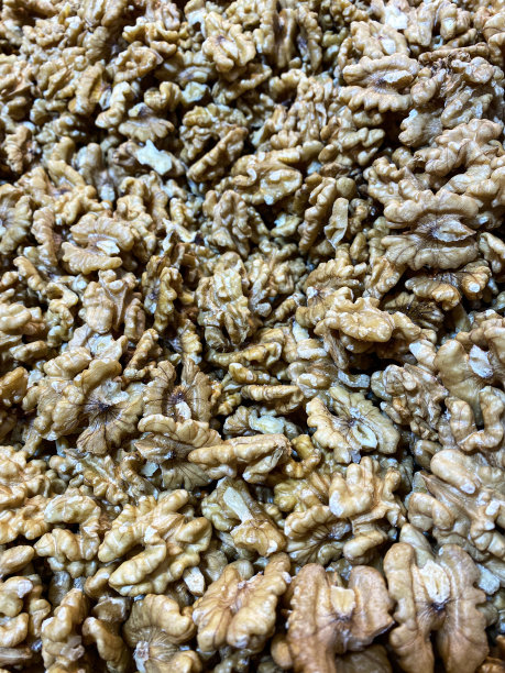 半截核桃堆的全帧图片，市场摊档按重量出售的显示，健康食品零食，抬高视图图片下载