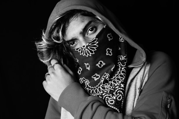 一个穿着连帽衫和大手帕的亚洲人的灰度镜头图片下载