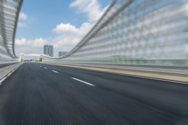 运动模糊散焦柏油路在市中心的桥与多云的天空图片下载