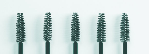 蓝色背景上的黑色睫毛刷和眉毛涂抹器。图片下载