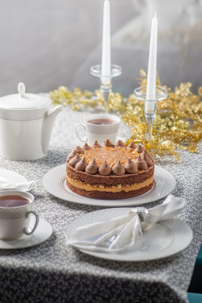圣诞餐桌上有蛋糕。圣诞节和新年的家庭茶话会。用金箔装饰的餐桌图片下载