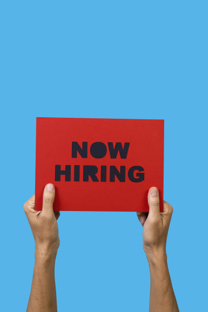 一名男子举着一个牌子，上面写着“现在招聘”图片下载
