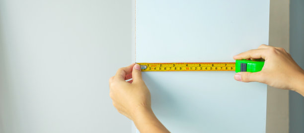 男人用卷尺测量家里的家具。DIY，室内设计，维修和改善家庭或公寓概念图片下载