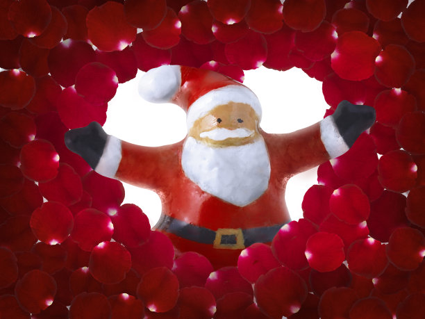 圣诞老人陶瓷雕像从红色玫瑰花瓣背景中出现图片下载