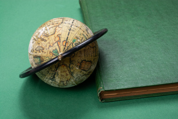 特写镜头的地球旁边的书为环境和保护-全球商业概念图片下载