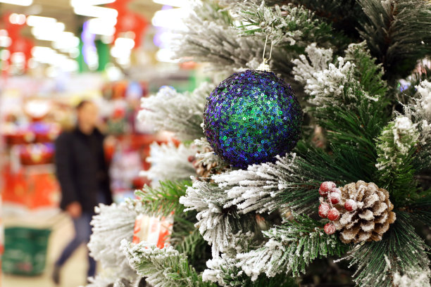 圣诞树上的玩具在购物中心的背景行走的人。新年装饰品，寒假和促销图片下载