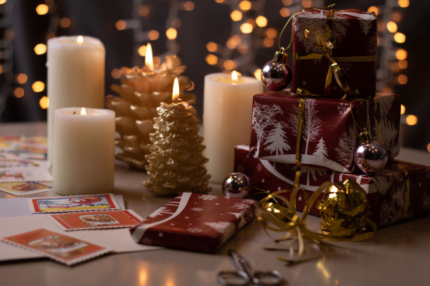 照片包装的礼物放在蜡烛旁边的桌子上图片下载