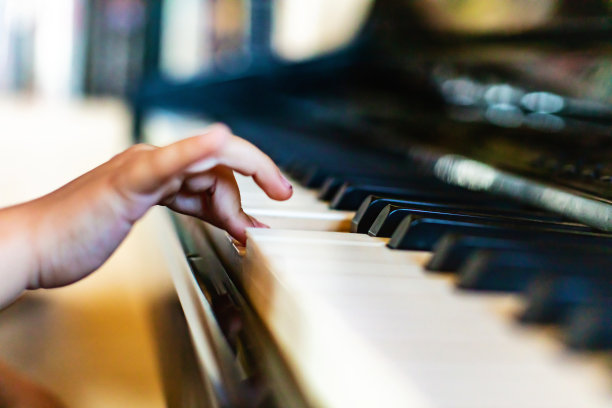 家庭房间里弹奏钢琴键盘的女孩照片系列图片下载