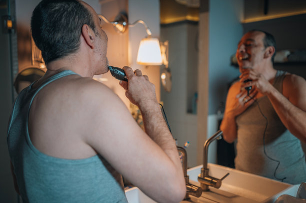 英俊的成熟男子剃须在浴室图片下载