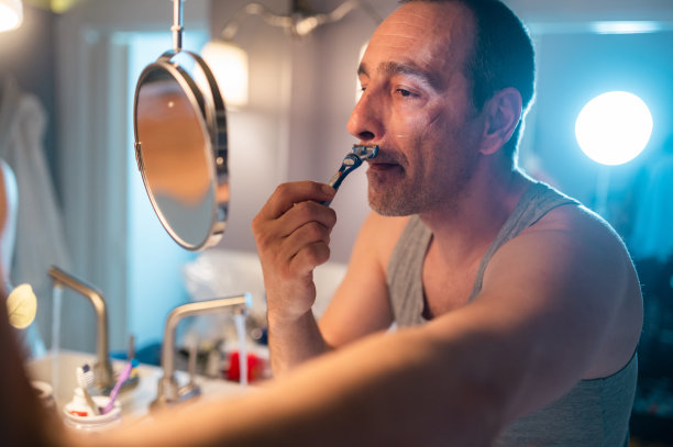 英俊的成熟男子剃须在浴室图片下载