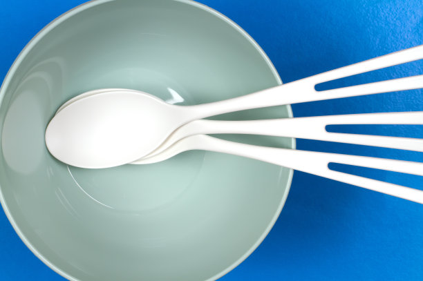 一套塑料器皿蓝色背景的盘子和勺子。图片下载