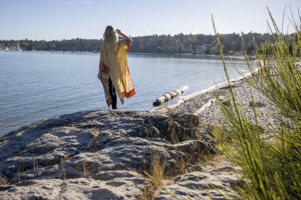 一名身穿和服的女子从海滩岩石上望向大海图片下载