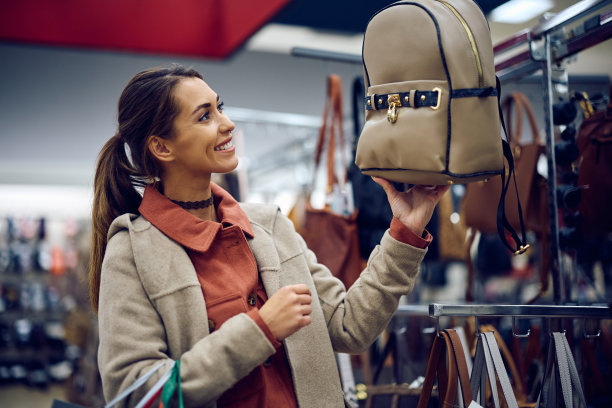 快乐的女人在购物中心买包。图片下载