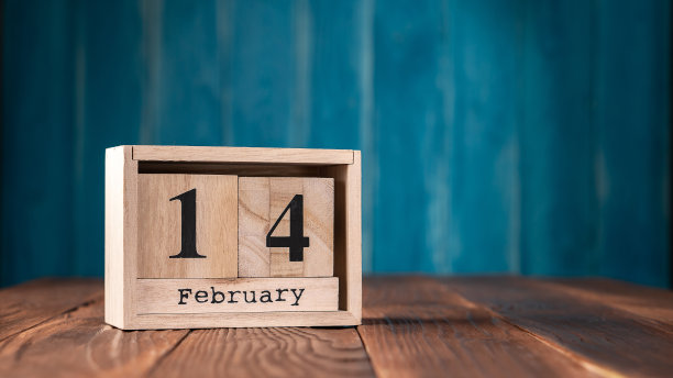 2月14日在木制日历上，蓝色背景上留有空白图片下载