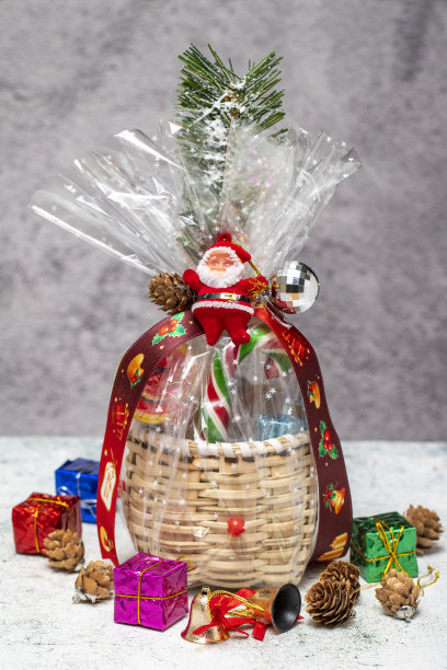 新年礼物。圣诞礼物与篮子上的灰色背景。包装准备巧克力，坚果，零食图片下载