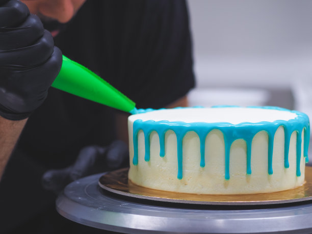 蛋糕设计师装饰顶部轻磨砂滴蛋糕和顶部与袋管填充图片下载