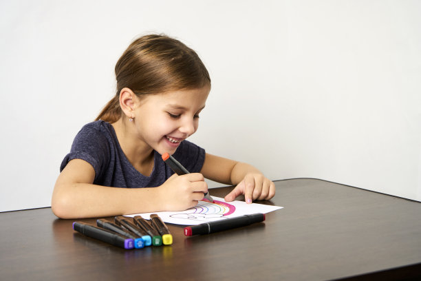 小女孩在桌子上画彩虹，闭眼图片下载