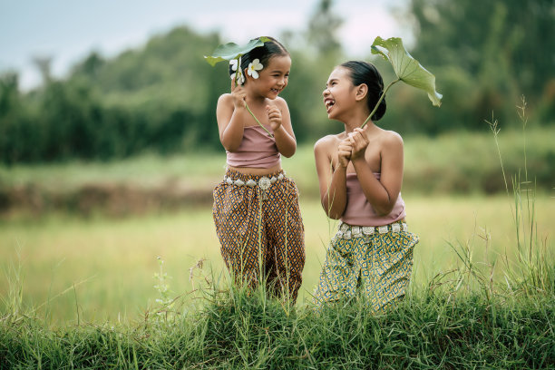 可爱的女孩们穿着泰国传统服饰，手拿荷叶图片下载