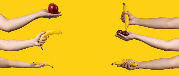 手与成熟的苹果，香蕉，李子孤立在黄色背景图片下载