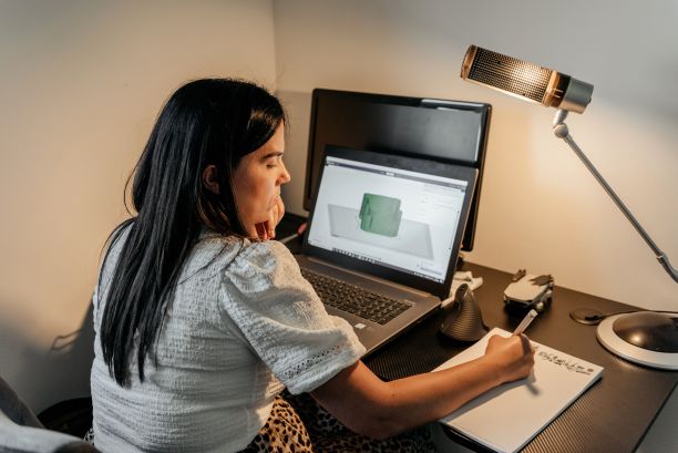 后面一位女士坐在办公桌前，用笔记本电脑工作图片下载