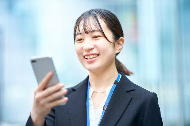 年轻女子在西装看智能手机图片下载