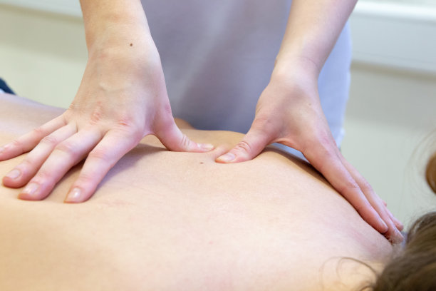 特写的按摩治疗师为病人提供背部按摩图片下载