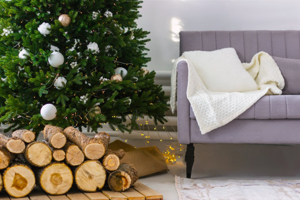 新年或圣诞节客厅内饰。沙发，格子，装饰的圣诞树，壁炉的柴火，彩灯花环图片下载