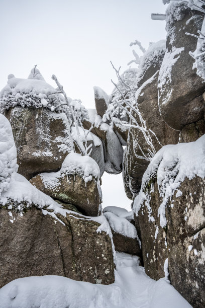 在冬天被雪覆盖的花岗岩巨石图片下载