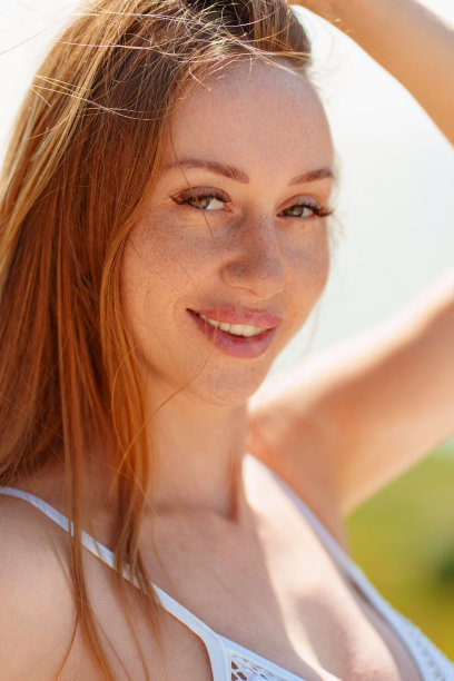 一个美丽和性感的年轻女子的肖像长头发在白色泳装。图片下载