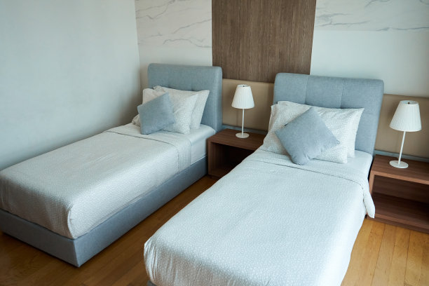 公寓内部酒店两张单人床和床头灯图片下载