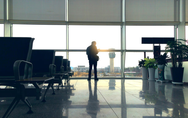 机场出发大厅里的空椅子，日落时分，控制塔和一架飞机起飞。旅行和交通概念。图片下载
