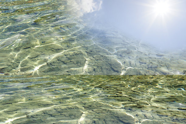 离焦模糊透明蓝色颜色清晰平静的水面纹理与飞溅和气泡。潮流抽象的自然背景。水波在阳光下复制空间。蓝色水彩闪光图片下载