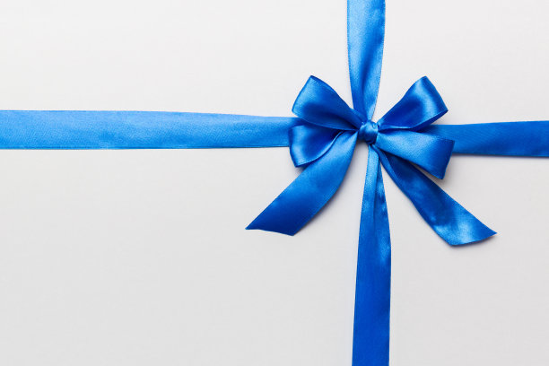 蓝色丝带卷和蓝色蝴蝶结孤立在彩色背景的俯视图。平面布局，复制空间图片下载