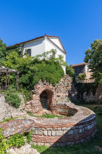 在公元5 -6世纪的拜占庭南圆塔废墟后面，你可以看到建于337年的古老异教神庙圣康斯坦丁和海伦娜教堂。保加利亚普罗夫迪夫(垂直照片)图片下载