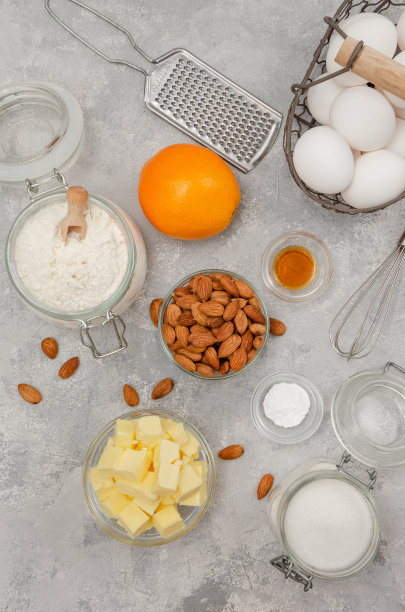 制作传统意大利坎图尼饼干的原料。面粉，黄油，鸡蛋，糖，杏仁，香草在灰色混凝土背景上。食谱一步一步来。图片下载