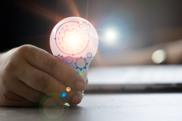 一个男人递上一个灯泡，灯泡上有一个齿轮图标，然后用电脑来寻找灵感。图片下载