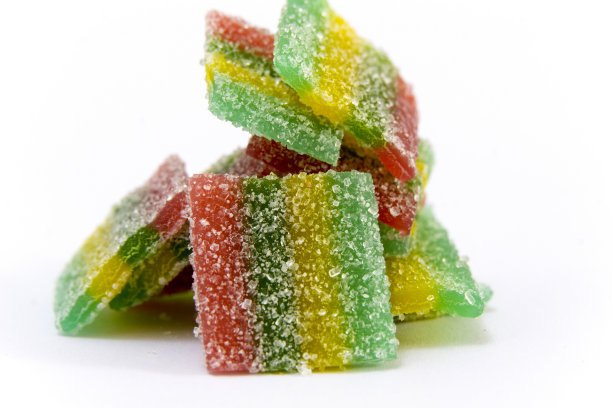 白色背景上点缀着彩虹条纹的糖糖果冻。彩色的糖糖果冻。彩虹糖果背景。特写图像。图片下载